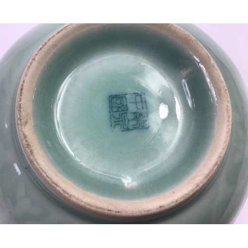 220 - A Chinese celadon bowl (15cm dia) with an embossed design of carp, with four characters signature to... 