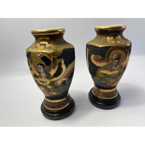 304 - A pair of old decorative JAPANESE SATSUMA VASES on dark wood stands - dimensions each vase 20cm tall... 