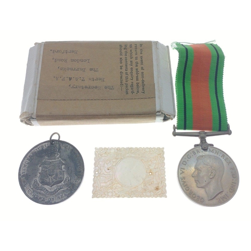 133 - WWII Defence Medal in box with certificate of issue. Also includes a mother of pearl oriental token ... 