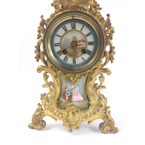 150 - A highly decorative continental MANTLE CLOCK in a brass scrolling case with applied painted scenes ,... 