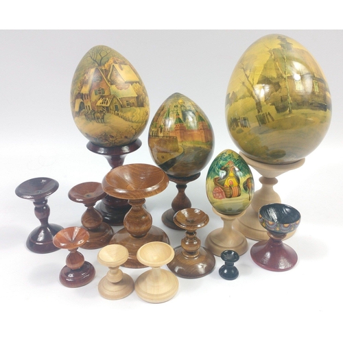 318 - Four decorated wooden eggs in shades of sepia the tallest being approx 12cm and 8 wooden egg stands ... 