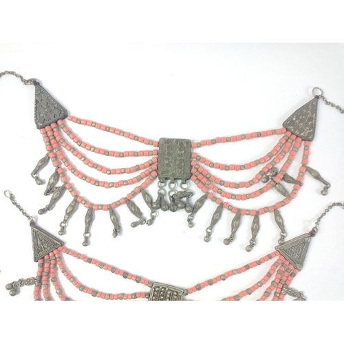 40 - Three substantial Middle Eastern coral coloured and white metal multi strand necklaces in good condi... 