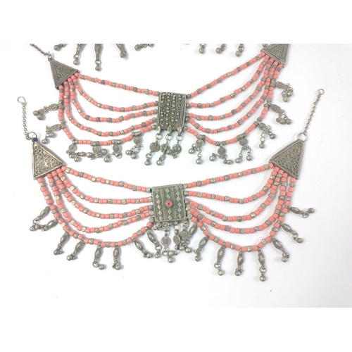 40 - Three substantial Middle Eastern coral coloured and white metal multi strand necklaces in good condi... 