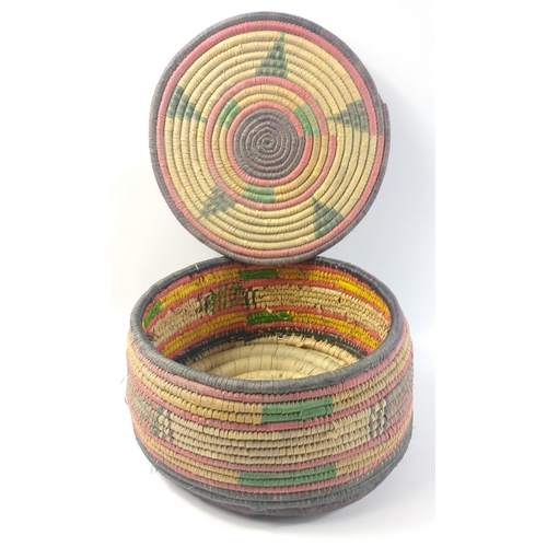 709 - A traditional colourful Middle Eastern woven basket with lid and leather base measuring approx 17cm ... 