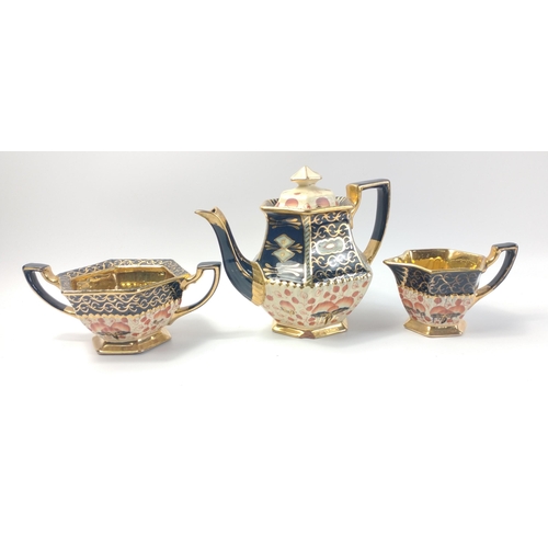 229 - A terracotta tea service comprising teapot, milk jug and sugar bowl all  in vibrant blue and gilt, t... 