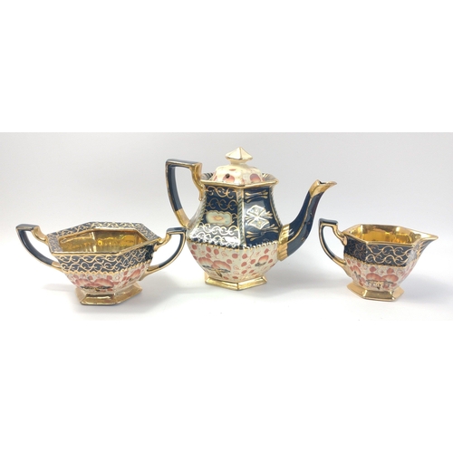 229 - A terracotta tea service comprising teapot, milk jug and sugar bowl all  in vibrant blue and gilt, t... 