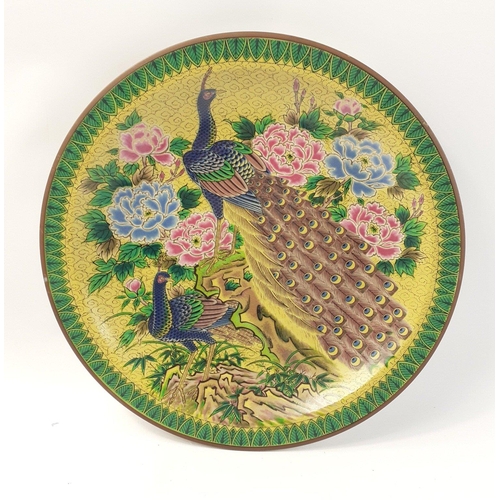 241 - An interesting and colourful far eastern wall plate with peacock and floral decoration. 32cm approx ... 