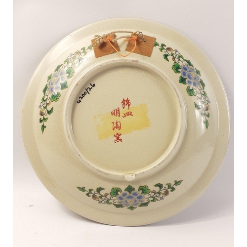 241 - An interesting and colourful far eastern wall plate with peacock and floral decoration. 32cm approx ... 