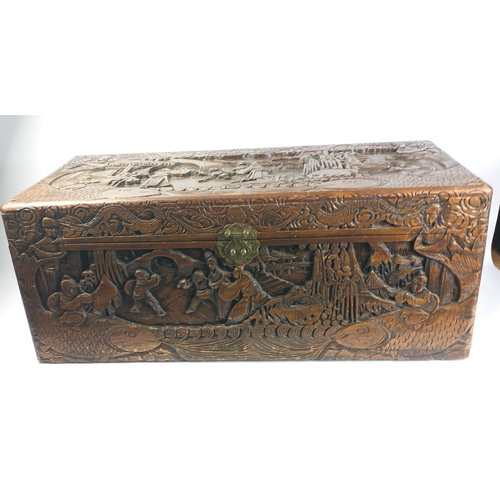 582 - A handy sized carved ORIENTAL wooden chest showing various traditional scenes on all sides , measure... 