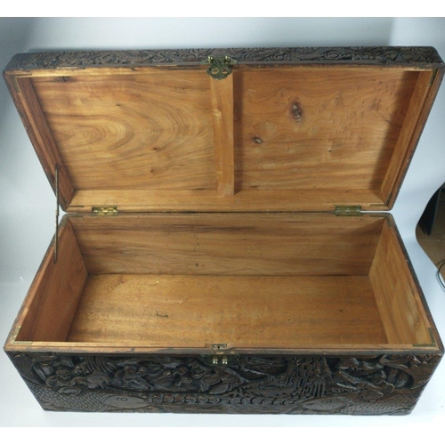 582 - A handy sized carved ORIENTAL wooden chest showing various traditional scenes on all sides , measure... 