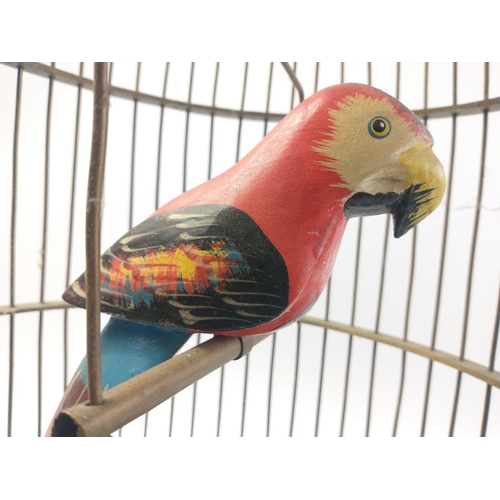 183 - A colourful wooden parrot in a brass cage which stands approx 53cm high, needs no feeding or cleanin... 