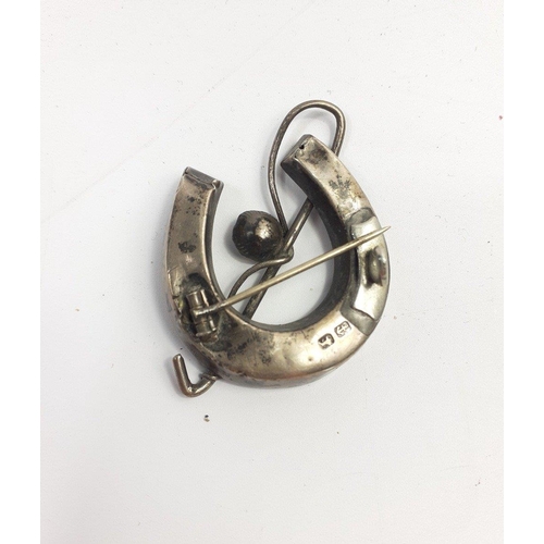 28 - EQUESTRIAN INTEREST - A silver brooch of a lucky horse shoe with a riding crop, hallmarked Birmingha... 