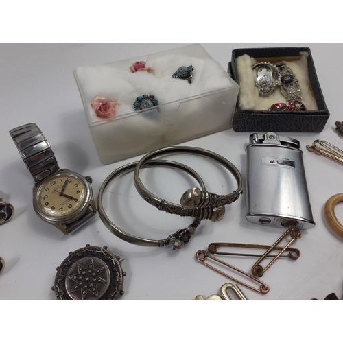 39 - A mixed bag of silver plate and white metal jewellery to include a nurse's buckle, a pair of collar ... 