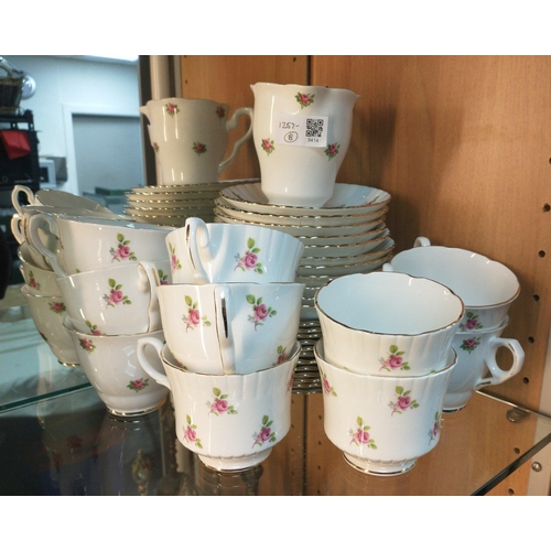 213 - A HOSTESS TABLEWARE tea service in white with rosebuds and gilt rim comprising, 10 teacups, 10 sauce... 