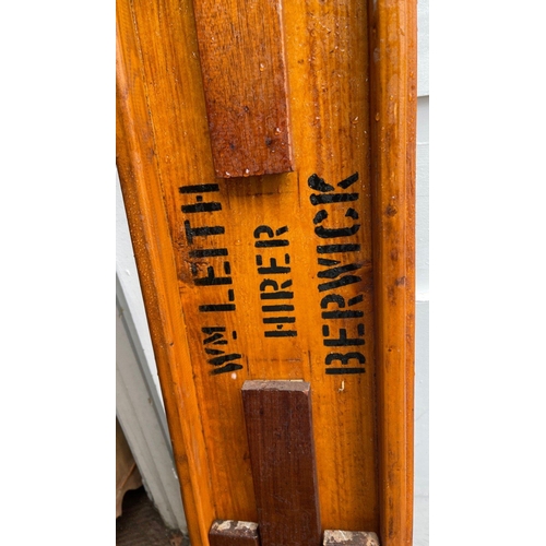 841 - An ANTIQUE folding wooden bench with Wm Leith Hirer Berwick painted on the underside - dimensions le... 