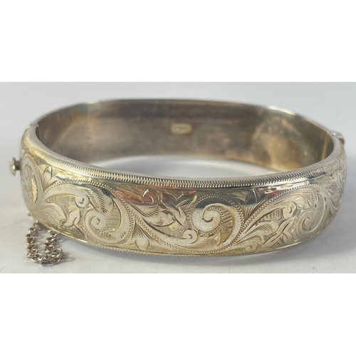 21 - AN ANTIQUE Lion hallmarked snap-shut silver bangle with swirly foliage decoration and comes with a s... 