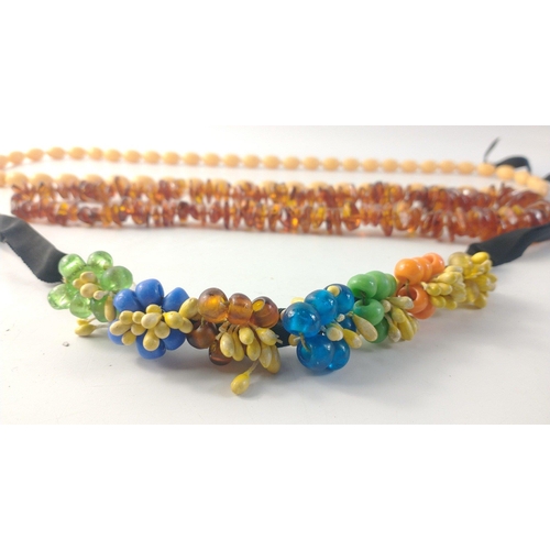 125 - A set of faux Amber beads, 56cm long approx. with a set of white plastic beads and a floral head ban... 