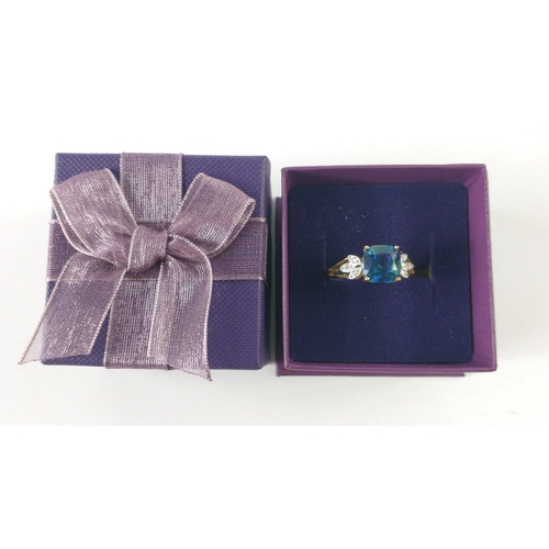 50 - A ring stamped 375 set with a large square central blue stone (1cm approx) set within 2 leaf shaped ... 