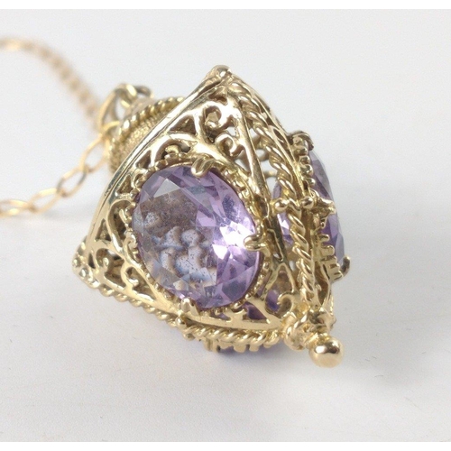 72 - A pomander style pendant and chain, both stamped 375, the pendant holds 3 large amethyst style stone... 