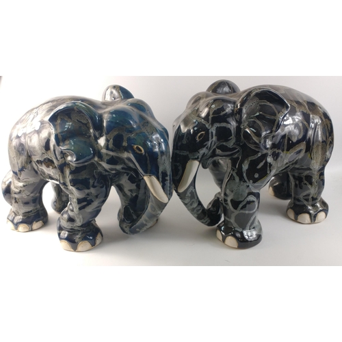 138 - An unusually attractive pair of ceramic elephants glazed in colours of blue/grey/black with random g... 