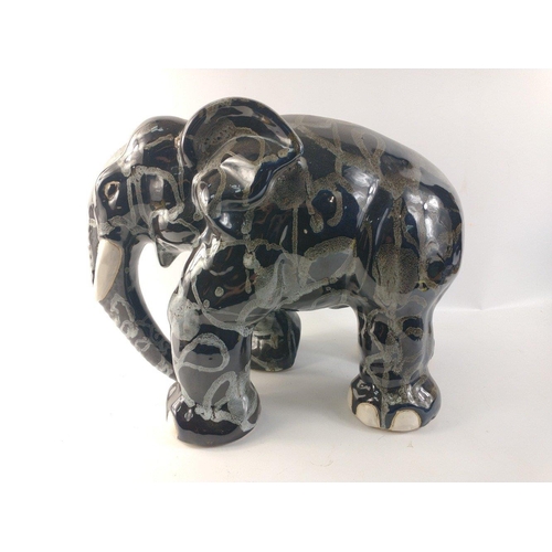 138 - An unusually attractive pair of ceramic elephants glazed in colours of blue/grey/black with random g... 