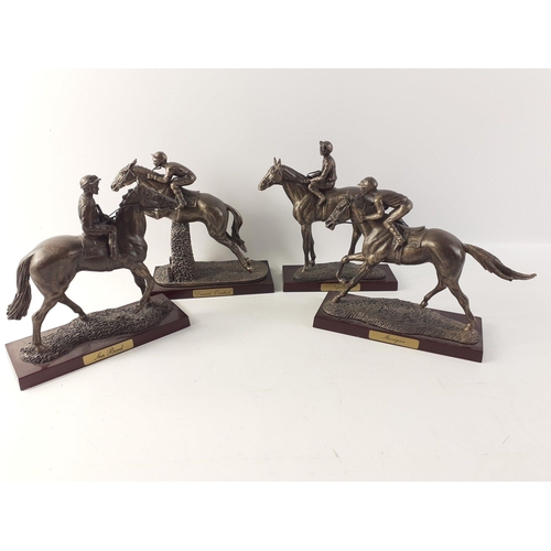 169 - A collection of four bronze effect resin models of race horses on plinths with jockeys.  Each stands... 