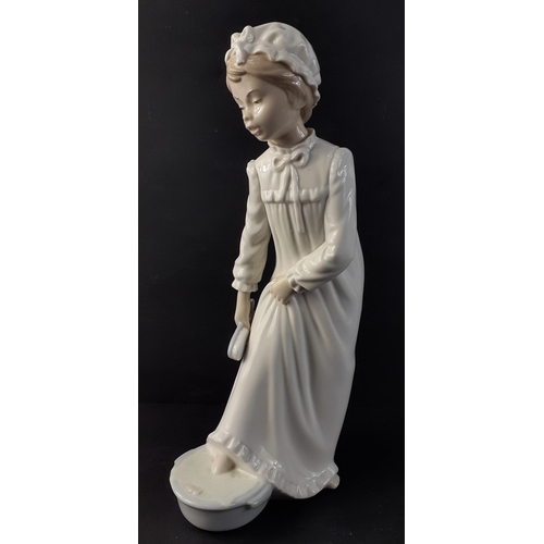 326 - A NAO figure of a girl washing her feet and readying herself for bed, standing 29cm high approx.  No... 