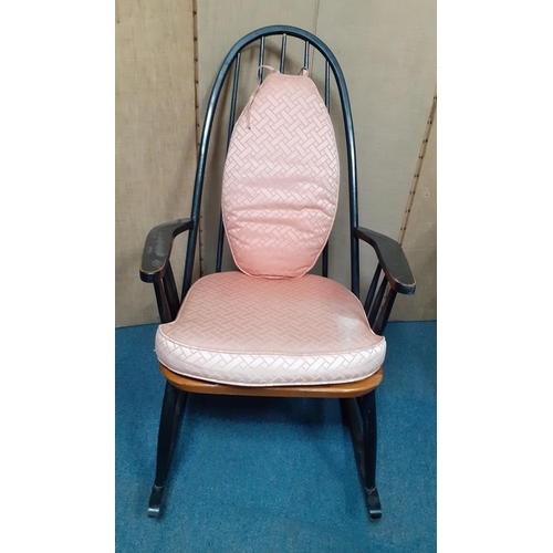 363 - A very comfy black painted wooden rocking chair with salmon pink seat and back cushions measuring ap... 