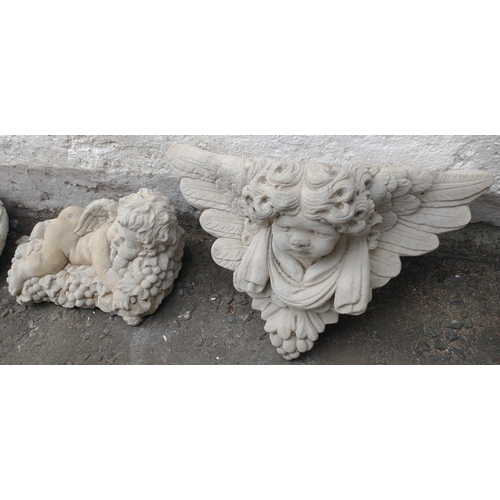 428 - Two cherub garden ornaments to include one lying on grapes (30cmL) and a wall hanging cherub planter... 