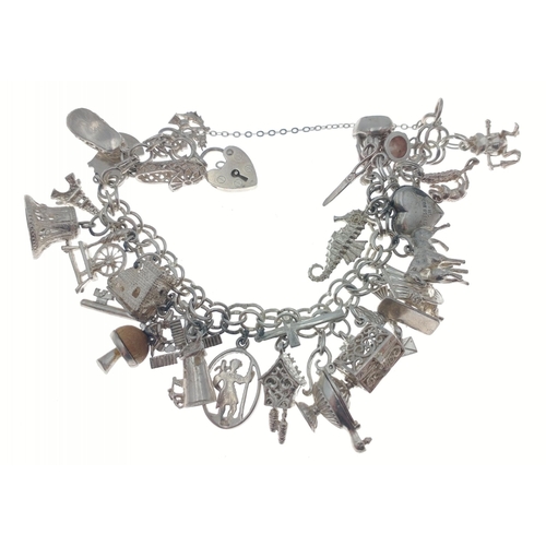 60 - A silver charm bracelet with lots of charms - weight gross 67.65g approx#9