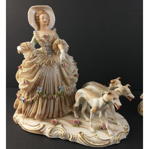 222 - A vintage German porcelain figurine of a lady with three greyhounds approx 23cm high.  There is dama... 