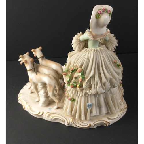 222 - A vintage German porcelain figurine of a lady with three greyhounds approx 23cm high.  There is dama... 