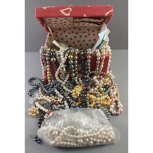 75 - A red fabric jewellery box decorated with white hearts and stuffed full of mainly faux pearls but al... 