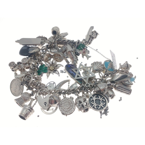 94 - Silver charm bracelet with many many superb charms and a gross weight of 141.5g approx.  A gorgeous ... 