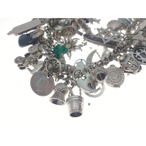 94 - Silver charm bracelet with many many superb charms and a gross weight of 141.5g approx.  A gorgeous ... 