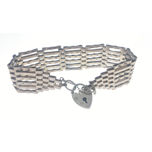 28F - A six bar open bracelet with safety chain and heart-shaped lock, stamped Sterling Silver 92, approx ... 