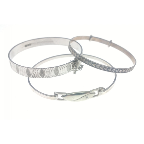 28H - Three silver bangles - an adjustable baby bangle, hallmarked Birmingham 2005, a bangle stamped 925 w... 