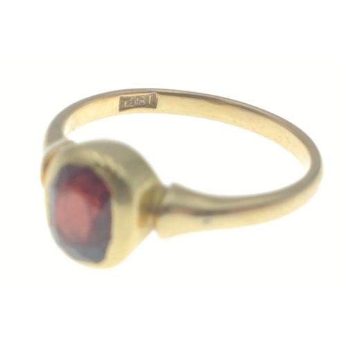 11 - An 18ct stamped yellow gold ring with a large garnet dimension of garnet 0.6 cm x 0.4cm approx gross... 