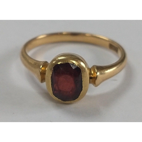 11 - An 18ct stamped yellow gold ring with a large garnet dimension of garnet 0.6 cm x 0.4cm approx gross... 