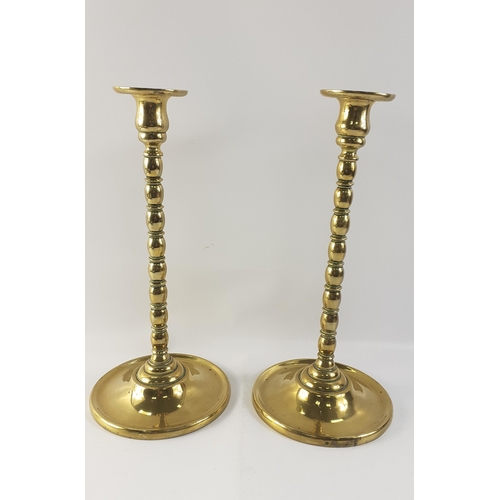 136 - An impressive pair of brass candlesticks standing 33cm tall. Both in very nice condition.#136