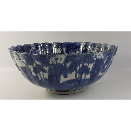 247 - A lovely blue and white Oriental bowl with fluted edges and a design of old gentlemen both inside an... 