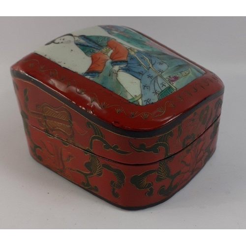 251 - An unusual red lacquered box with a heavy ceramic lid with hand-painted Oriental ladies, measures 11... 