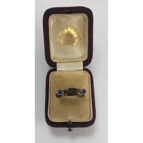 9 - A 375 stamped yellow gold ring with two unusual blue stones with a larger Smokey quartz stone centre... 