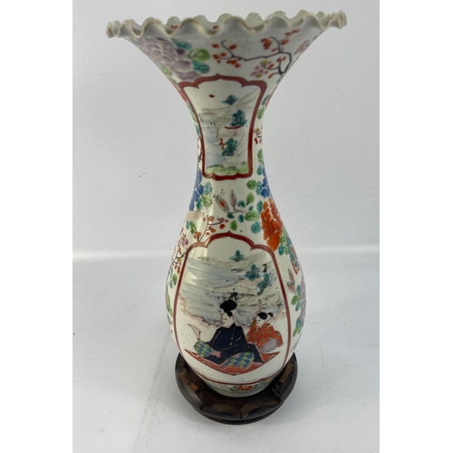 234 - An Oriental vase with fluted rim standing 30cm high with slight damage to rim on a wooden stand#38... 