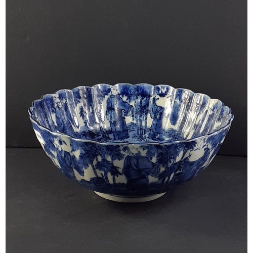 247 - A lovely blue and white Oriental bowl with fluted edges and a design of old gentlemen both inside an... 