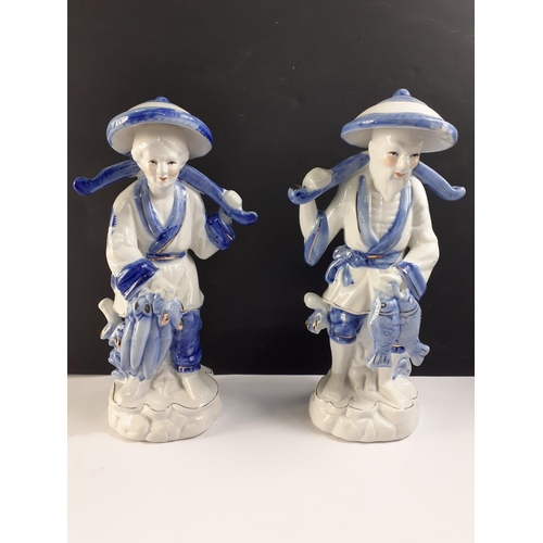 274 - Two Chinese fisherfolk figurines of a man and woman after a successful fishing trip.  Each stands ap... 