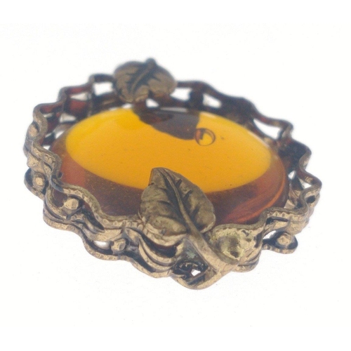 11 - A vintage pendant with an amber bead 20mm x20mm set in a yellow metal surround held in with 4 leaves... 