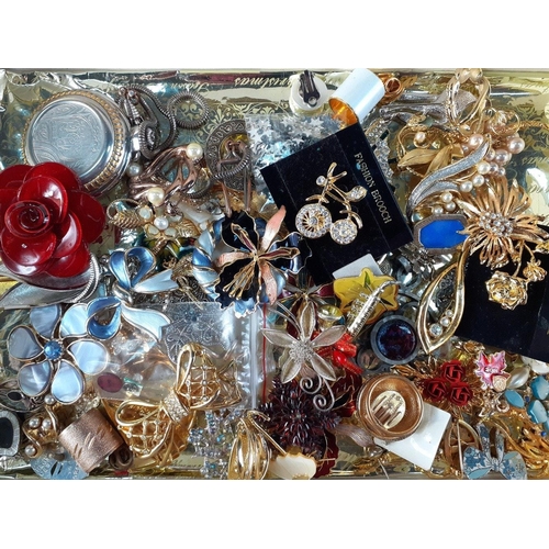 22 - A boxed collection of costume jewellery to include many enamelled brooches, a ROJAS pocket watch, an... 