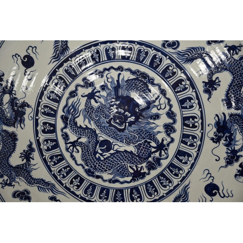 18 - A very heavy large porcelain charger plate with a hand painted dragon design. Approximately 5ft in d... 