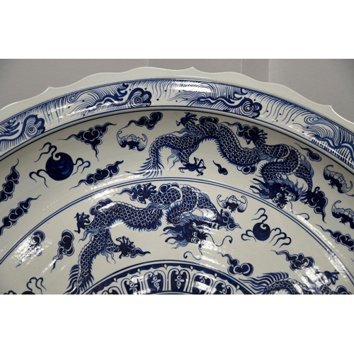 18 - A very heavy large porcelain charger plate with a hand painted dragon design. Approximately 5ft in d... 